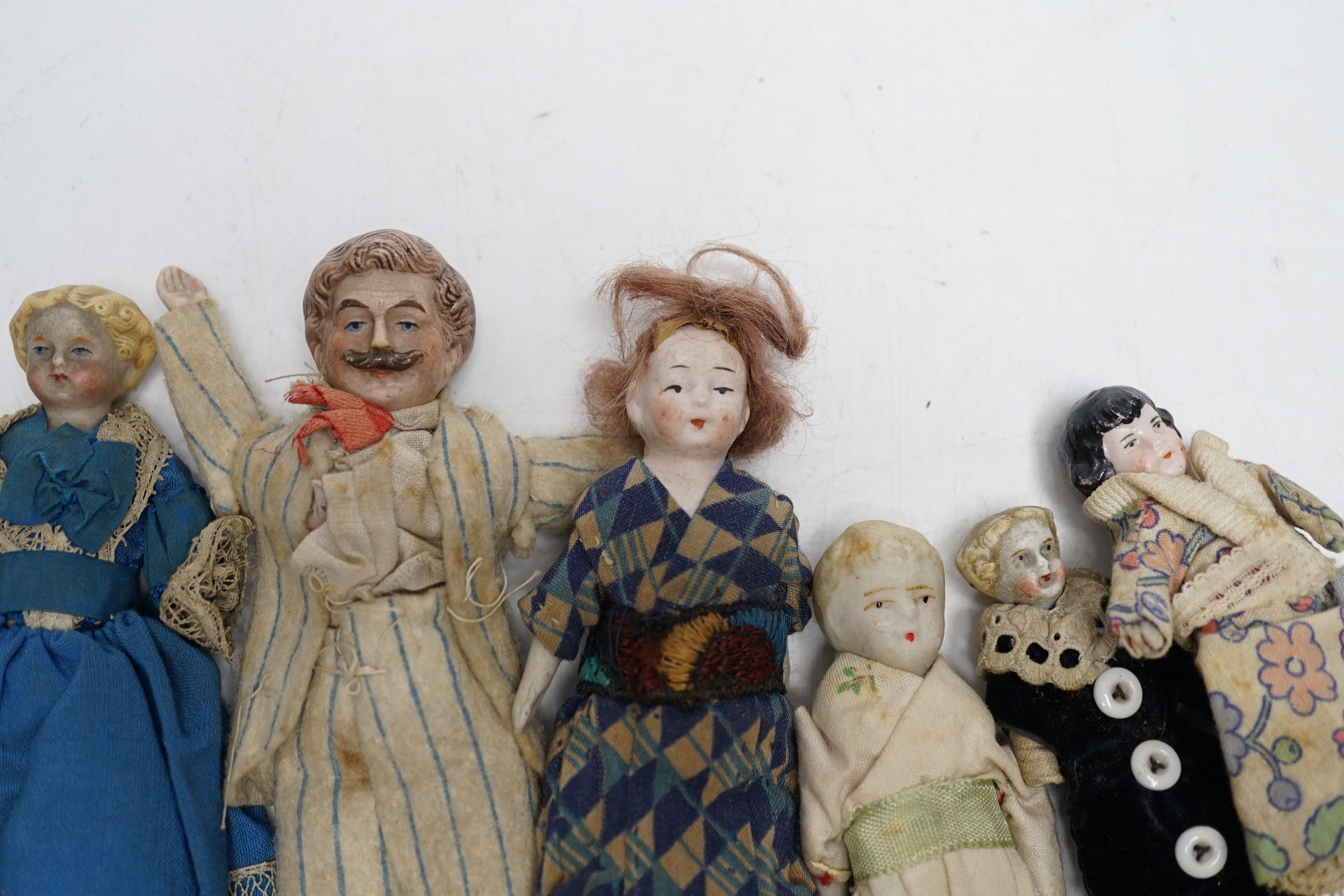 Six doll's house dolls, two c.1860 and a male figure with moustache, two other bisque later figures and one small doll, damaged